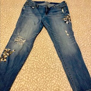 Torrid jeans with decorative embroidered flowers.